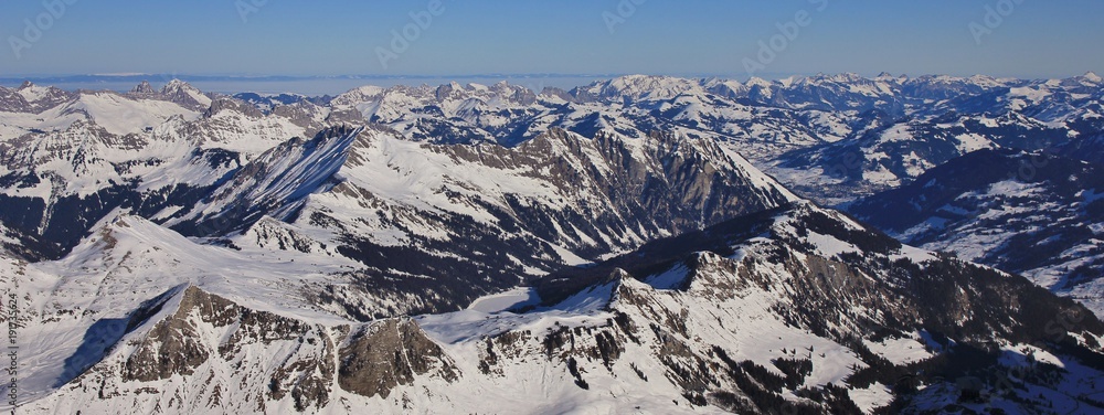 Frozen lake Arnensee and mountain ranges near Gstaad, Switzerland. View from glacier des Diablerets.