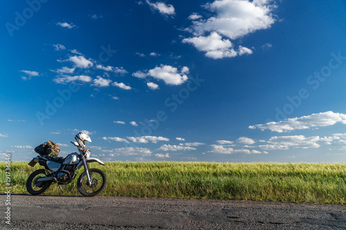off road dual sport enduro motorcycle on the road between rice fields at sunset, travel concept design