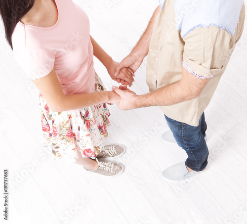 Young couple in love holding hands isolated on white background. Top view unusual angle horizontally.