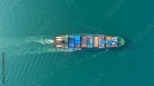 Container ship in export and import business and logistics. Shipping cargo to harbor by crane. Water transport International. Aerial view