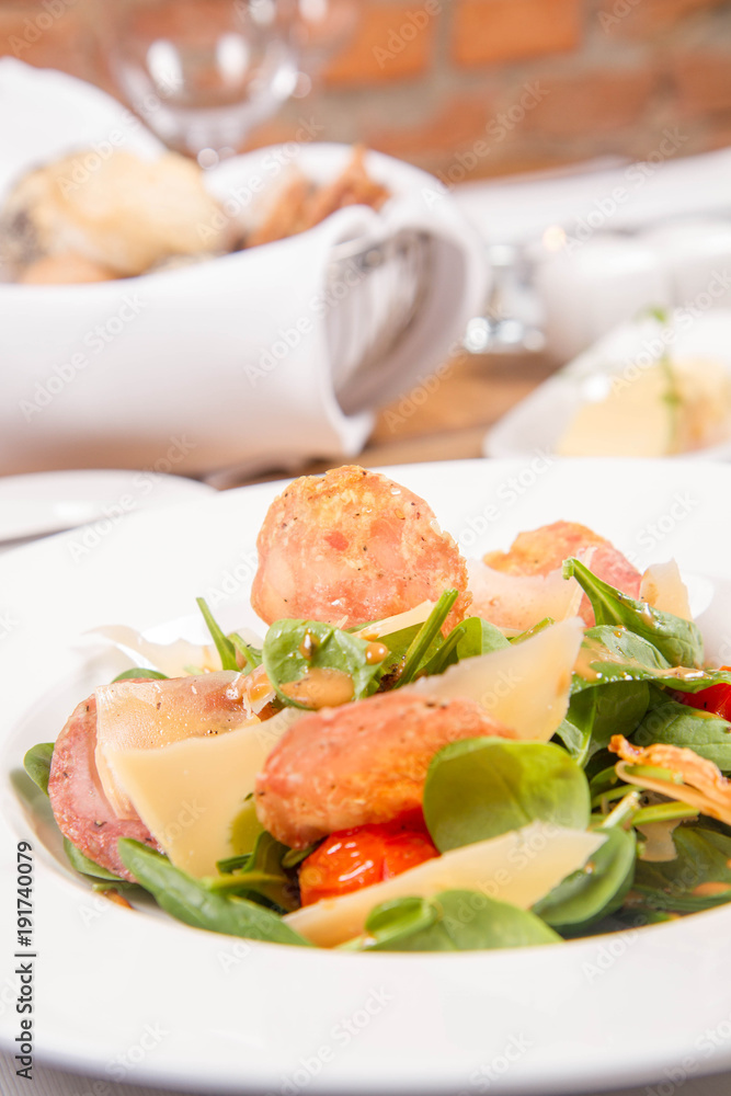 Baby spinach, dry sausage, matured cheese, roast tomatoes, thyme-balsamic vinaigrette salad served in a restaurant Baby spinach, dry sausage, matured cheese, roast tomatoes, thyme-balsamic vinaigrette salad served in a restaurant