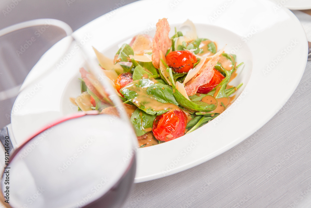 Baby spinach, dry sausage, matured cheese, roast tomatoes, thyme-balsamic vinaigrette salad served in a restaurant Baby spinach, dry sausage, matured cheese, roast tomatoes, thyme-balsamic vinaigrette salad served in a restaurant