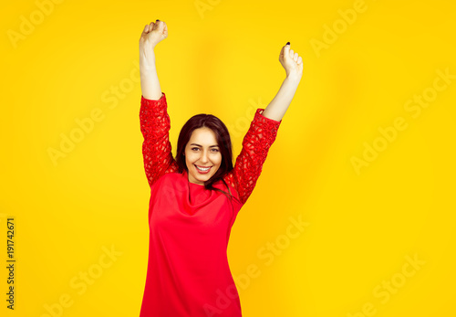 beautiful young happy woman on a yellow background