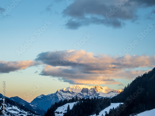 An early sunrise on the snowcapped mountains in Switzerland © gdefilip