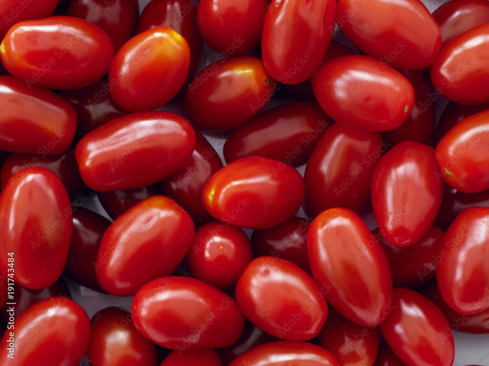 Full frame vibrant red miniature plum tomatos Full frame vibrant red miniature plum tomatos