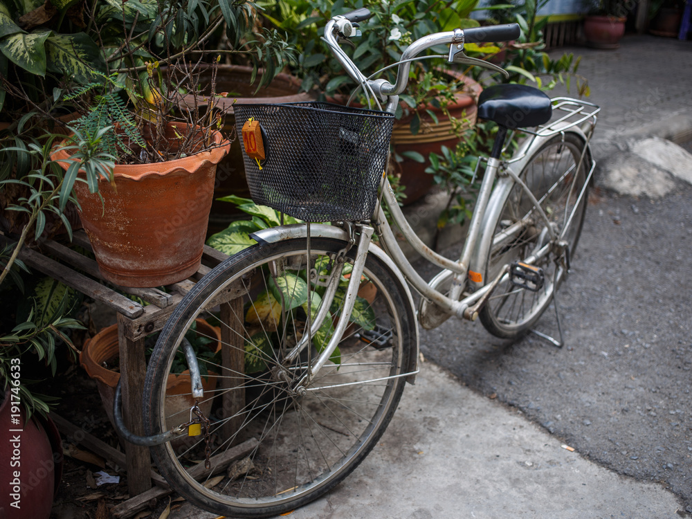 Bicycle with basket is parked in street