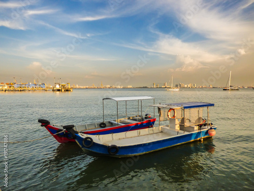 Speed boats at the Clan Jetties of Georgetown with a city view and a dramatic blue sky in the background - Penang  Malaysia
