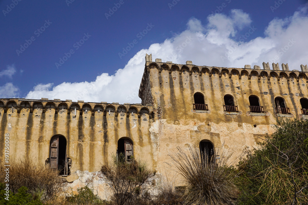 Abandoned building with blue sky and clouds in background