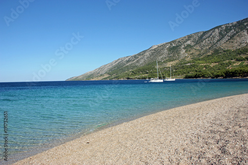 Beach with blue sea water and parked yachts