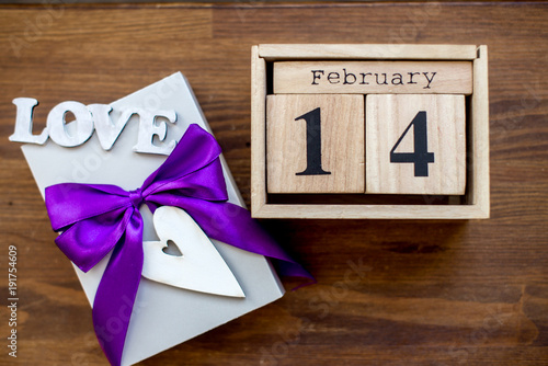 Gift box on the wooden background. Violet ribbon. Valentine's Day gift. photo