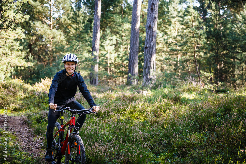 Obraz premium Young man biking in forest