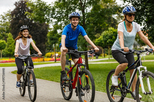 Healthy lifestyle - people riding bicycles in city park