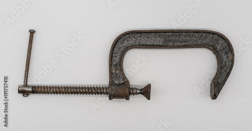 Vintage adjustable  clamp for carpenter work in an old traditional style wood working workshop photo