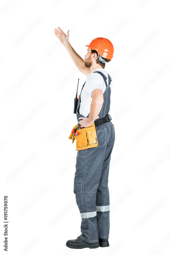 A construction man stands with his back and shows his hand. Repair and construction. Isolated over white background. A construction man stands with his back and shows his hand. Repair and construction. Isolated over white background.