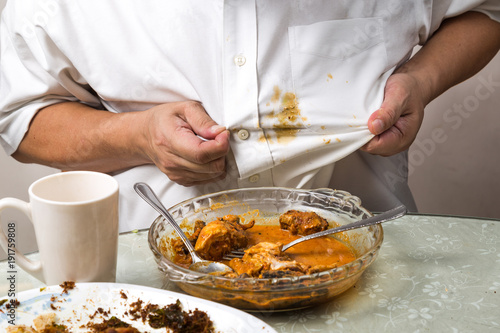 Person accidently spilled curry stain onto white shirt.