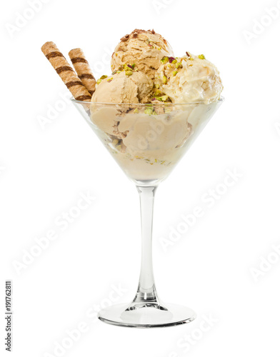 Creme brulee ice cream with nuts and wafer stick in glass vase