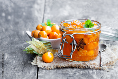 Homemade  physalis jam in jar on wooden table photo