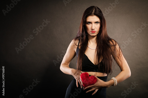 Bild auf Leinwand Beautiful woman holds red heart on black