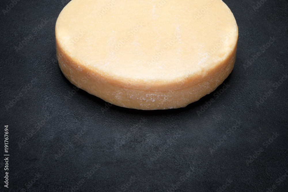 Whole round Head of parmesan or parmigiano hard cheese on concrete background Whole round Head of parmesan or parmigiano hard cheese on concrete background