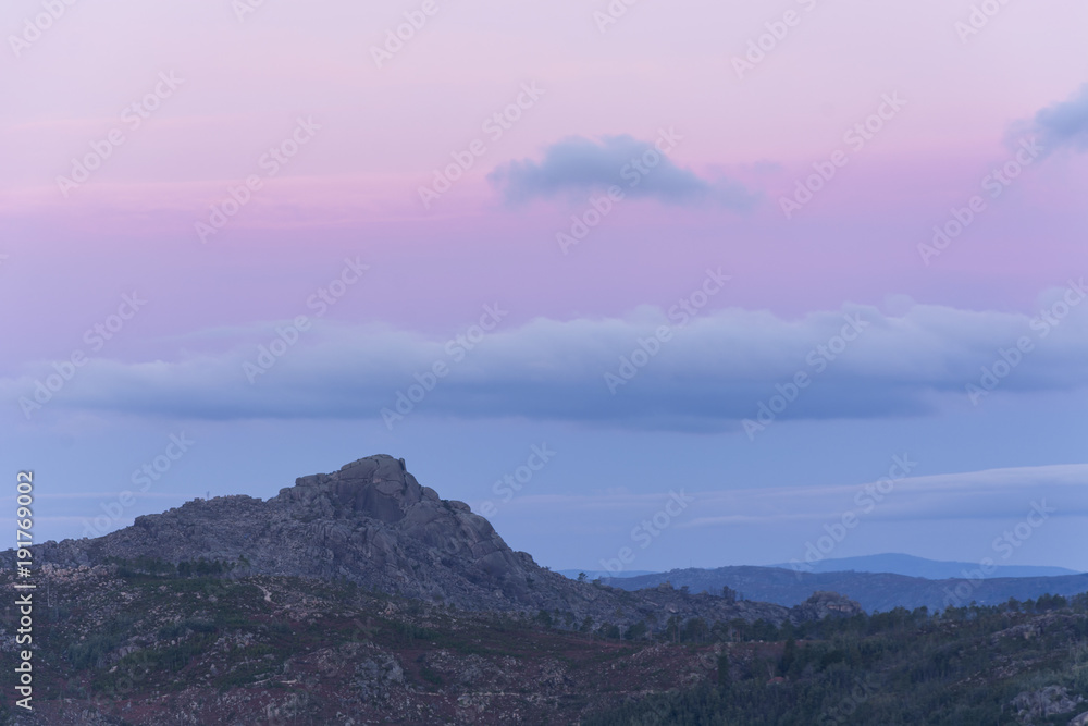 Obraz premium Sunrise in the mountains of Gerês. Rugged mountains and sky with orange/purple clouds 