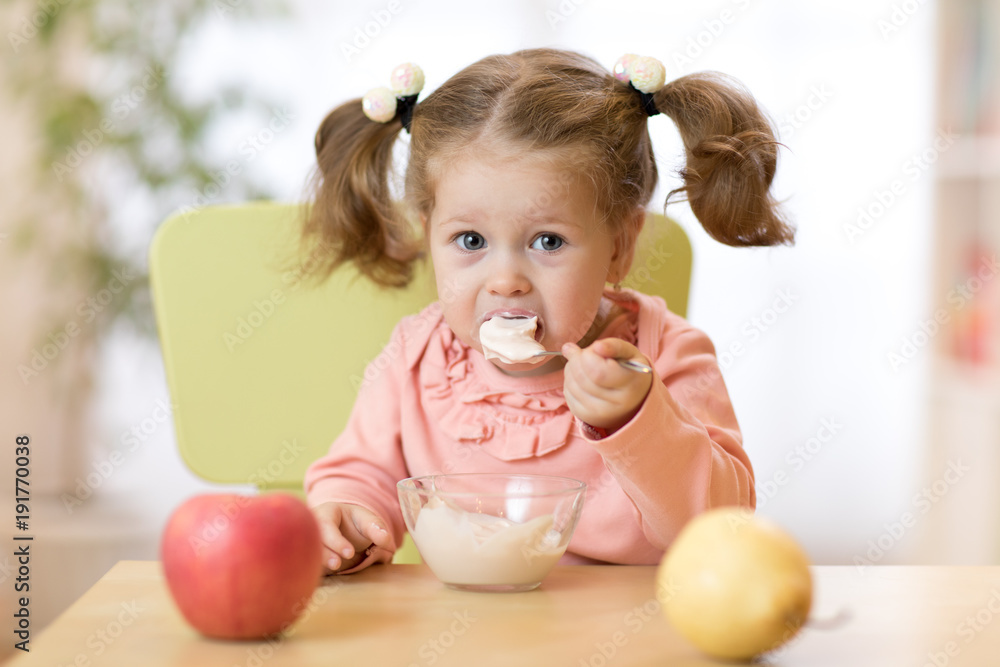 child eating healthy food at home or kindergarten