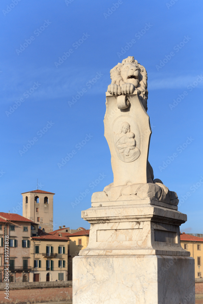 Lion statue on the entrance of Ponte Solferino, a bridge on the Arno river in Pisa, Italy