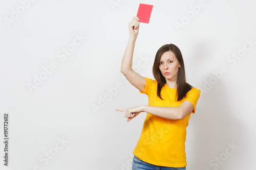 European serious severe young woman, football referee in yellow uniform show red soccer card, propose player retire from field isolated on white background. Sport, play, healthy lifestyle concept. photo