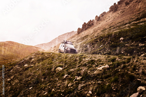 Offroad SUV in den Bergen, bei Sonnenuntergang und Regen