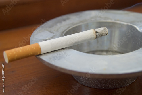 Burning cigarette smoking on ashtray