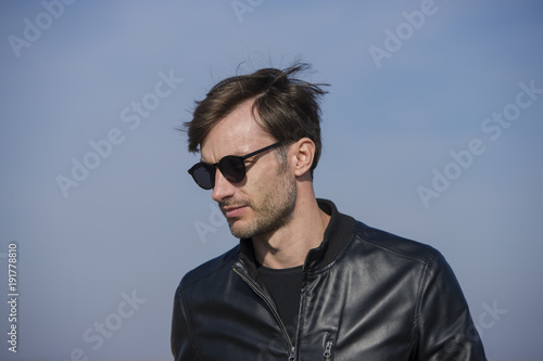 portrait of a handsome man in sunglasses on the street. © APHOTOSTUDIO