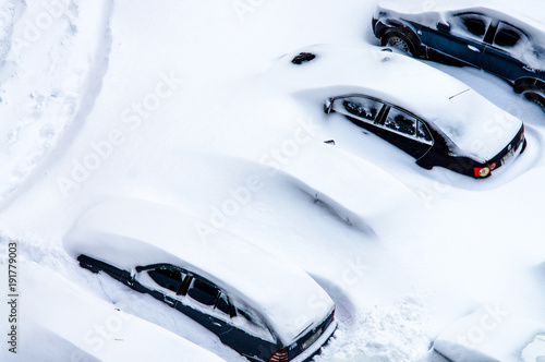 After a snowstorm, cars in the parking lot are covered with a thick layer of snow