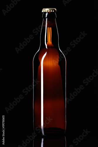 Closed bottle of beer on a black background. © Igor Normann