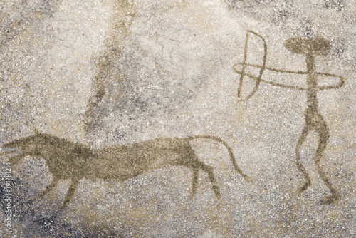 The scene of the ancient man's hunting on the wall of the cave.