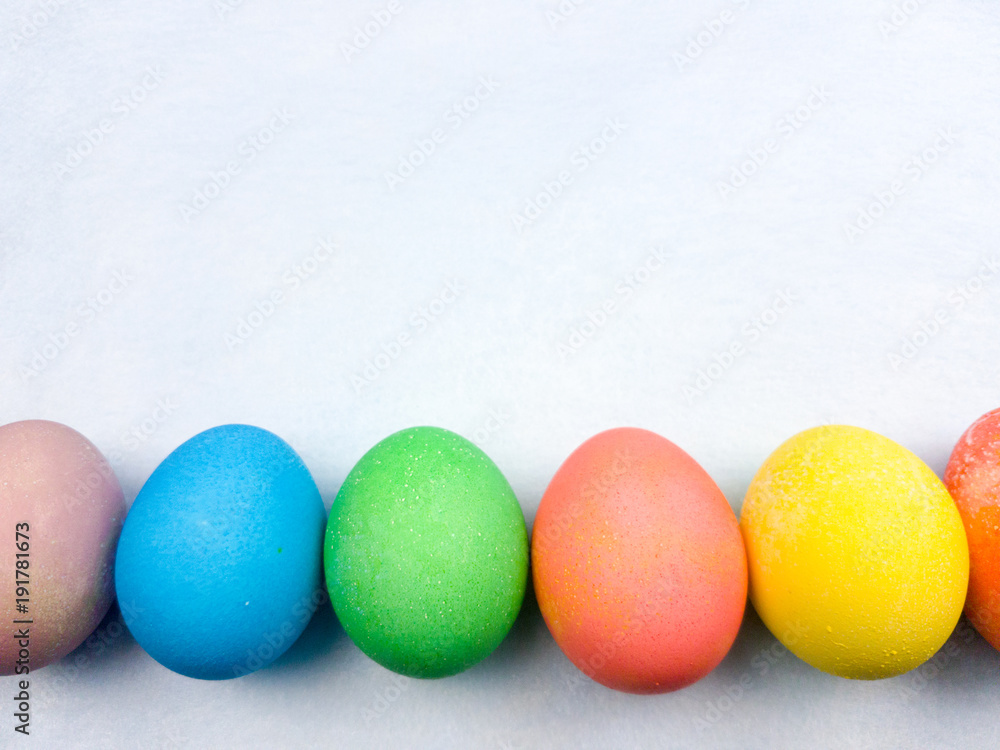 Color easter eggs on pastel blue background. Close up.