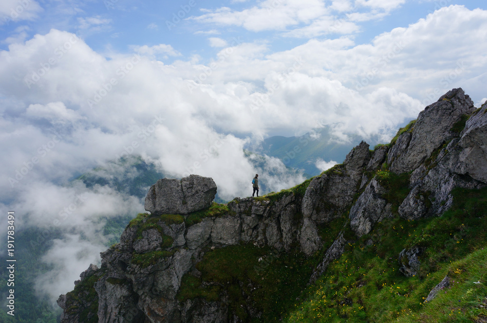 Woman standing at the mountain edge against the cloudy sky, Little Fatra , Slovakia