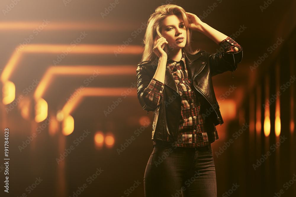 Young fashion blond woman in leather jacket talking on cell phone Young fashion blond woman in leather jacket talking on cell phone