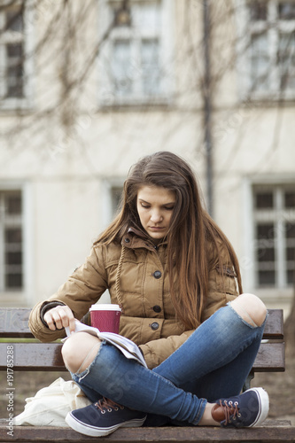 Young woman reading book sitting on a bench © MEM Stocks