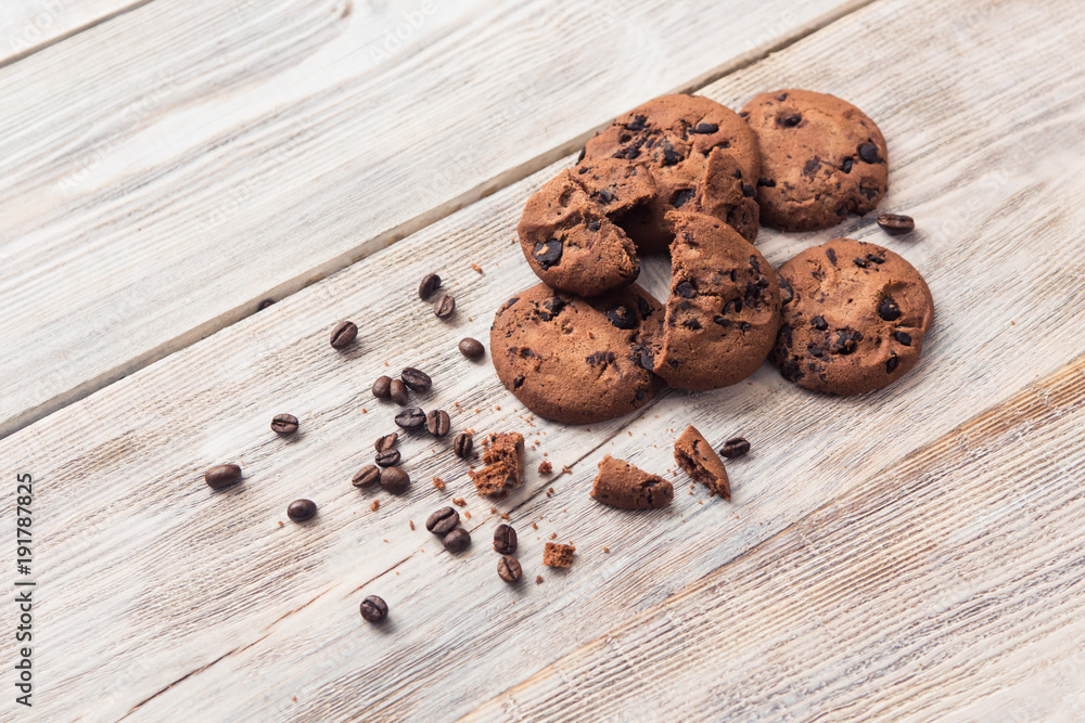 broken chocolate chip cookies with coffee beans on white wooden table