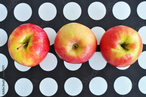 three apples on background black and white dots, fresh fruits, healthy snack photo