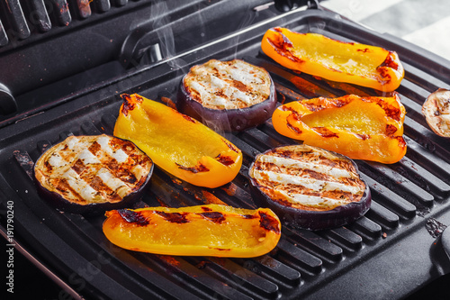 Vegetables: aubergines and yellow pepper on an electric grill. Close-up. Healthy Eating