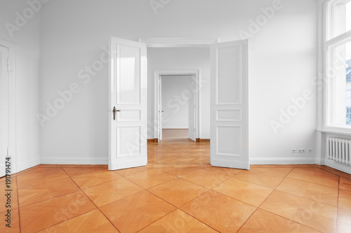 renovated empty apartment  with double wing door and parquet floor