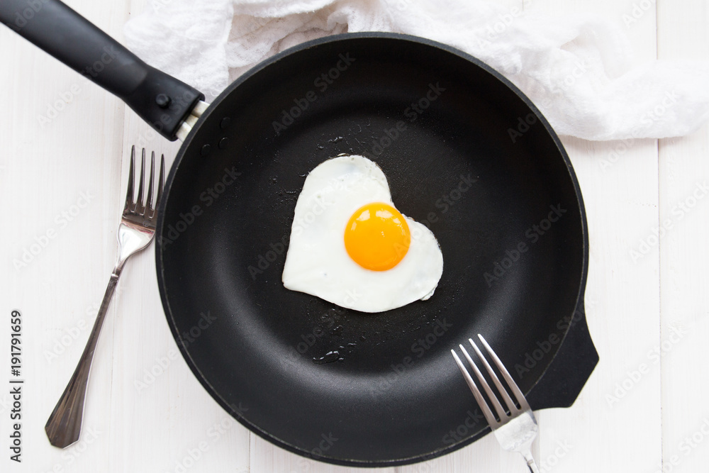 heart-shaped fried eggs in a black pan heart-shaped fried eggs in a black pan