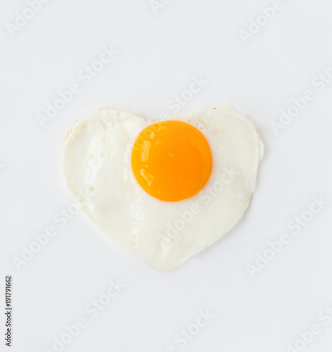fried egg in heart shape on a white plate love