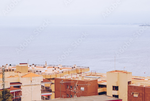 View of bright houses and roofs. Sea background