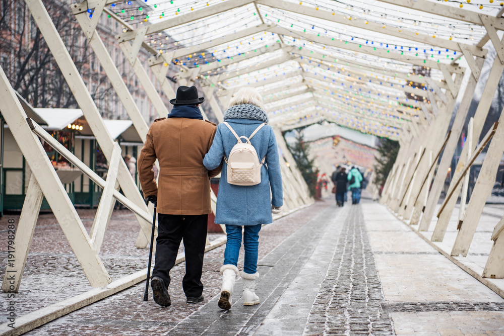 Back view of serene old man and woman walking along beautiful street in the winter. Copy space Back view of serene old man and woman walking along beautiful street in the winter. Copy space