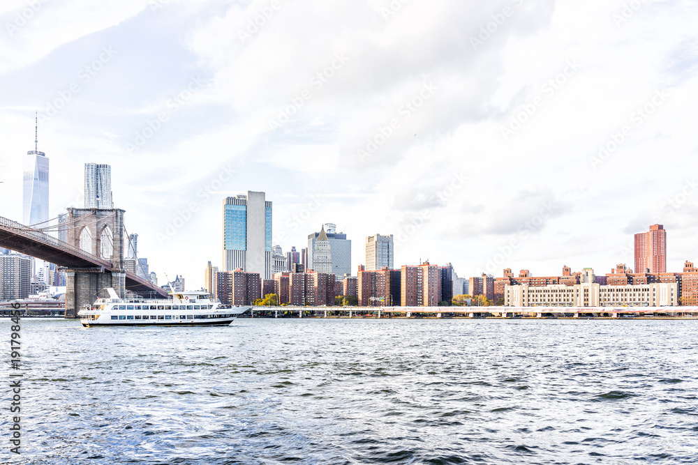 East river water with view of NYC New York City cityscape skyline, Brooklyn bridge, ship boat ferry swimming by midtown