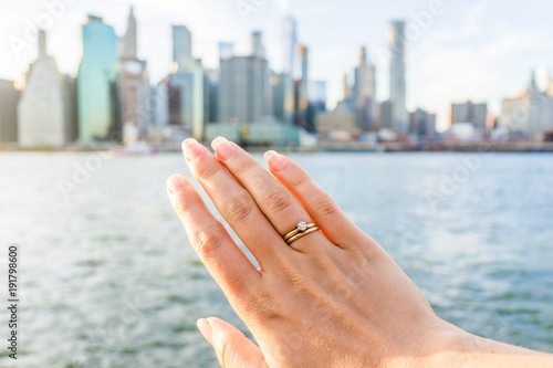 Εκτύπωση καμβά Young woman's hand with diamond engagement ring solitaire, gold wedding band out
