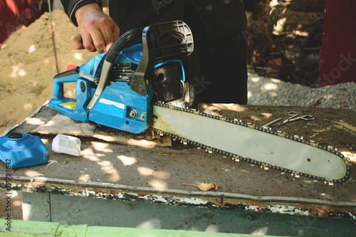 close-up portrait of chainsaw. How to choose a chainsaw, instructions for use.a man fills up a chainsaw. 