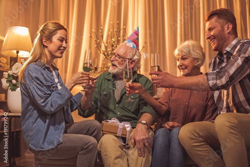 Cheerful family celebrating birthday. They drinking glasses of champagne. Party concept