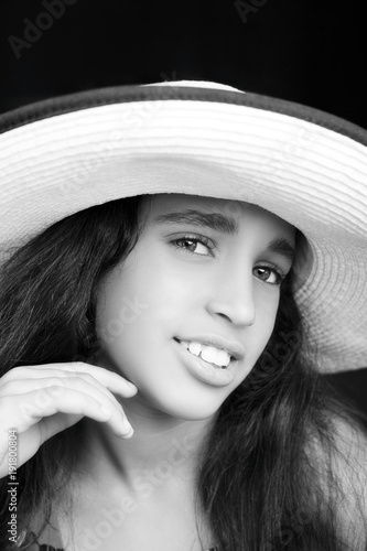 Portrait of a young african american girl laughing with sun hat